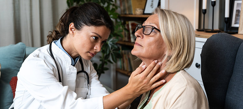 Un femme médecin ausculte le cou d'une patiente - La Prévention Médicale