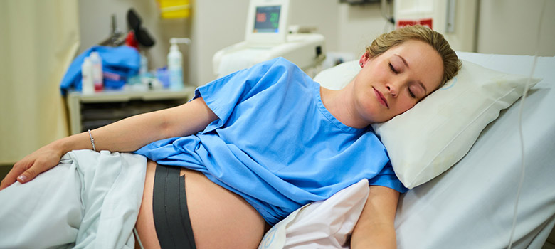 Une femme enceinte sous monitoring dort - La Prévention Médicale