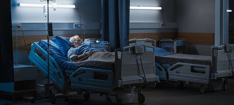 Un homme âgé allongé dans un lit d'hôpital - La Prévention Médicale