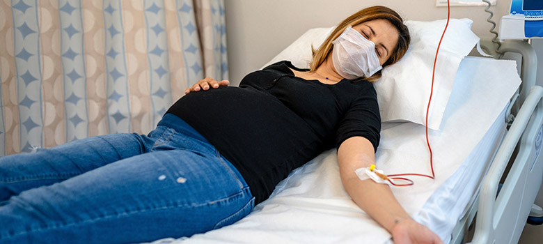 Femme enceinte allongée sous perfusion - La Prévention Médicale