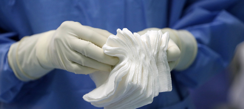 Un soignant compte les compresses stériles au bloc opératoire - La prévention Médicale