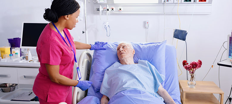 Une infirmière est au chevet d'un patient âgé - La Prévention Médicale