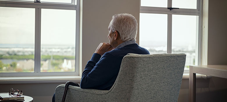 Homme agé regarde par la fenêtre | La Prévention Médicale