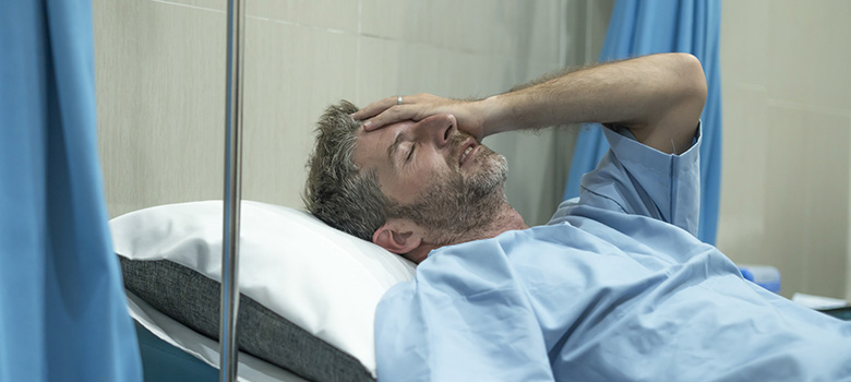 Un homme souffrant sur le lit de l'hôpital - La Prévention Médicale