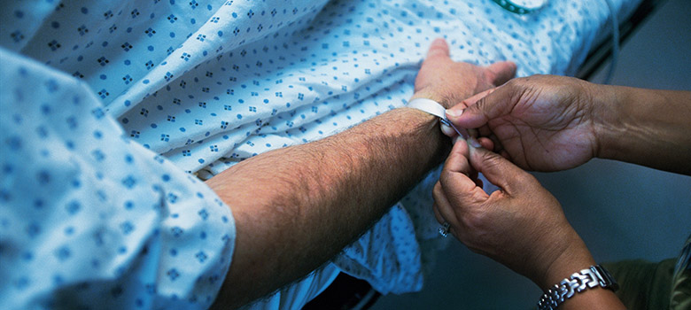 Un professionnel de santé pose un bracelet d'identité à un patient hospitalisé - La Prévention Médicale