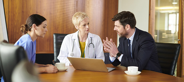 Trois professionnels de santé discutent autour d'une table - La Prévention Médicale