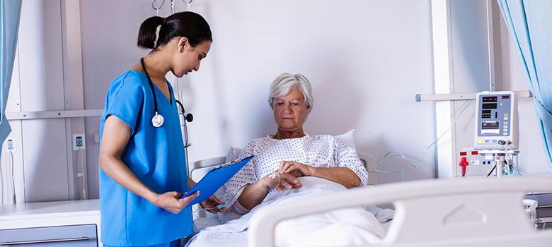 Une infirmière regarde la perfusion d'une patiente âgée à l'hôpital - La Prévention Médicale