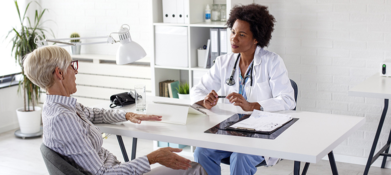 Une femme d'âge mûr discute avec son médecin - La Prévention Médicale
