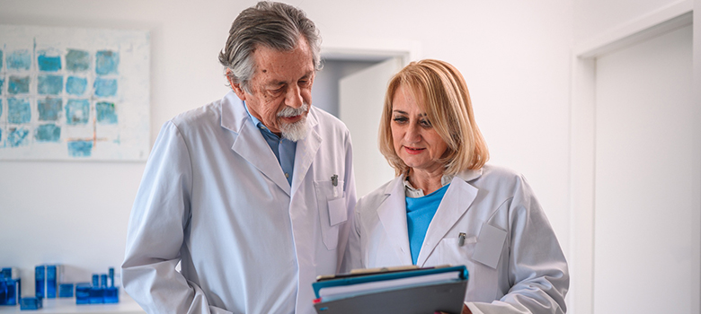 Un médecin examine un dossier médical avec sa consœur - La Prévention Médicale