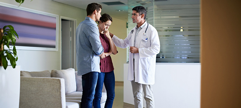 Un médecin discute avec un couple dans la salle d'attente - La Prévention Médicale Un médecin discute avec un couple dans la salle d'attente - La Prévention Médicale