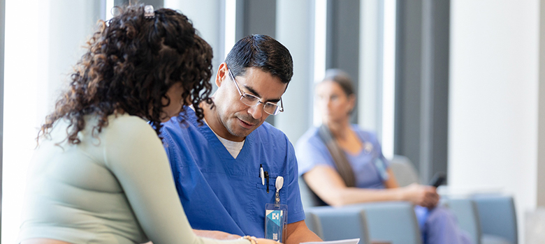 Un infirmier parle avec une patiente dans la salle d'attente de l'hôpital - La Prévention Médicale