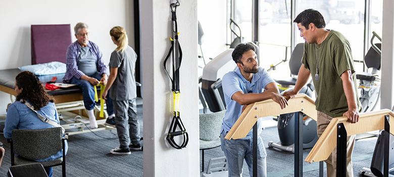 Des kinés discutent avec des patients dans une salle de rééducation - MACSF Des kinés discutent avec des patients dans une salle de rééducation - MACSF