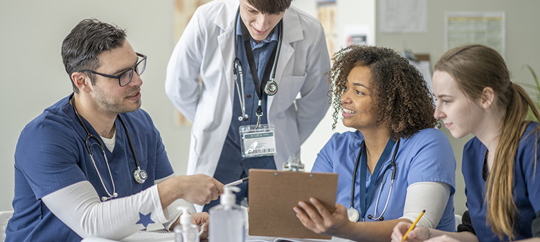 Une médecin senior apporte des explications à des étudiants en médecine - La Prévention Médicale