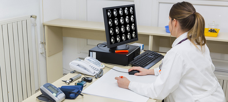 Une femme médecin regarde les résultats d'un scanner sur son ordinateur - La Prévention Médicale