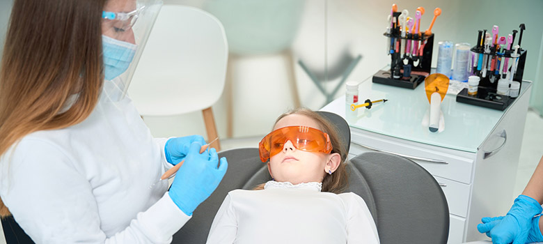 Une dentiste soigne une enfant - La Prévention Médicale