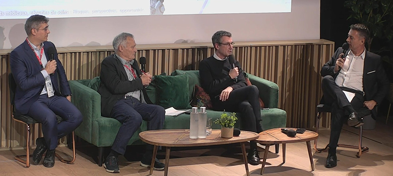 Quatre hommes participent à une table ronde, assis sur des fauteuils, échangeant avec des micros autour d’une table basse. - La Prévention Médicale Quatre hommes participent à une table ronde, assis sur des fauteuils, échangeant avec des micros autour d’une table basse. - La Prévention Médicale