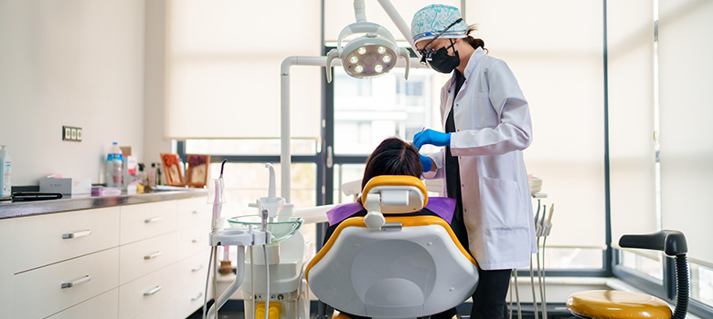 Une dentiste pratique des soins sur une patiente - La Prévention Médicale