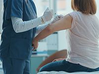 Une infirmière réalise une injection dans le bras d'une patiente - La Prévention Médicale