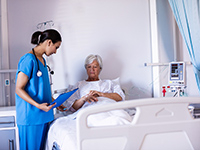 Une infirmière regarde la perfusion d'une patiente âgée à l'hôpital - La Prévention Médicale