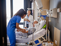 Une infirmière pose une perfusion à un homme âgée à l'hôpital - La Prévention Médicale