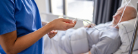 Une infirmière vérifie la perfusion d'un patient âgé alité - La Prévention Médicale Une infirmière vérifie la perfusion d'un patient âgé alité - La Prévention Médicale