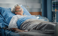 Une septuagénaire portant un masque à oxygène est allongée dans son lit d'hôpital - La Prévention Médicale Une septuagénaire portant un masque à oxygène est allongée dans son lit d'hôpital - La Prévention Médicale