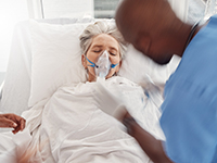 Un infirmier pose un masque de ventilation à une patiente - MACSF