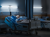 Un homme âgé allongé dans un lit d'hôpital - La Prévention Médicale
