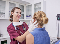 Une femme médecin ausculte le cou d'une jeune femme - La Prévention Médicale
