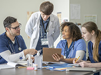 Une médecin senior apporte des explications à des étudiants en médecine - La Prévention Médicale