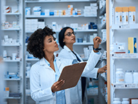 Deux pharmaciennes sélectionnent des médicaments dans la réserve - La Prévention Médicale