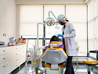 Une dentiste pratique des soins sur une patiente - La Prévention Médicale
