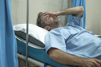 Un homme souffrant sur le lit de l'hôpital - La Prévention Médicale