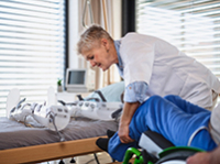 Une femme aide un homme en fauteuil roulant - La Prévention Médicale