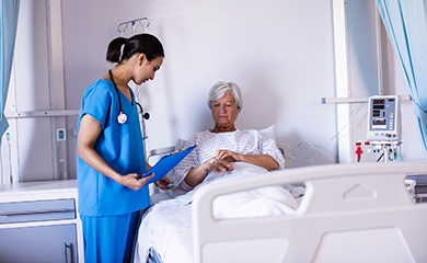 Une infirmière regarde la perfusion d'une patiente âgée à l'hôpital - La Prévention Médicale