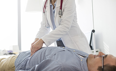 Un médecin pratique une palpation abdominale sur un patient - La Prévention Médicale