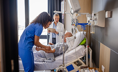 Une infirmière pose une perfusion à un homme âgée à l'hôpital - La Prévention Médicale Une infirmière pose une perfusion à un homme âgée à l'hôpital - La Prévention Médicale